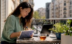 Woman writing value proposition notes at home desk