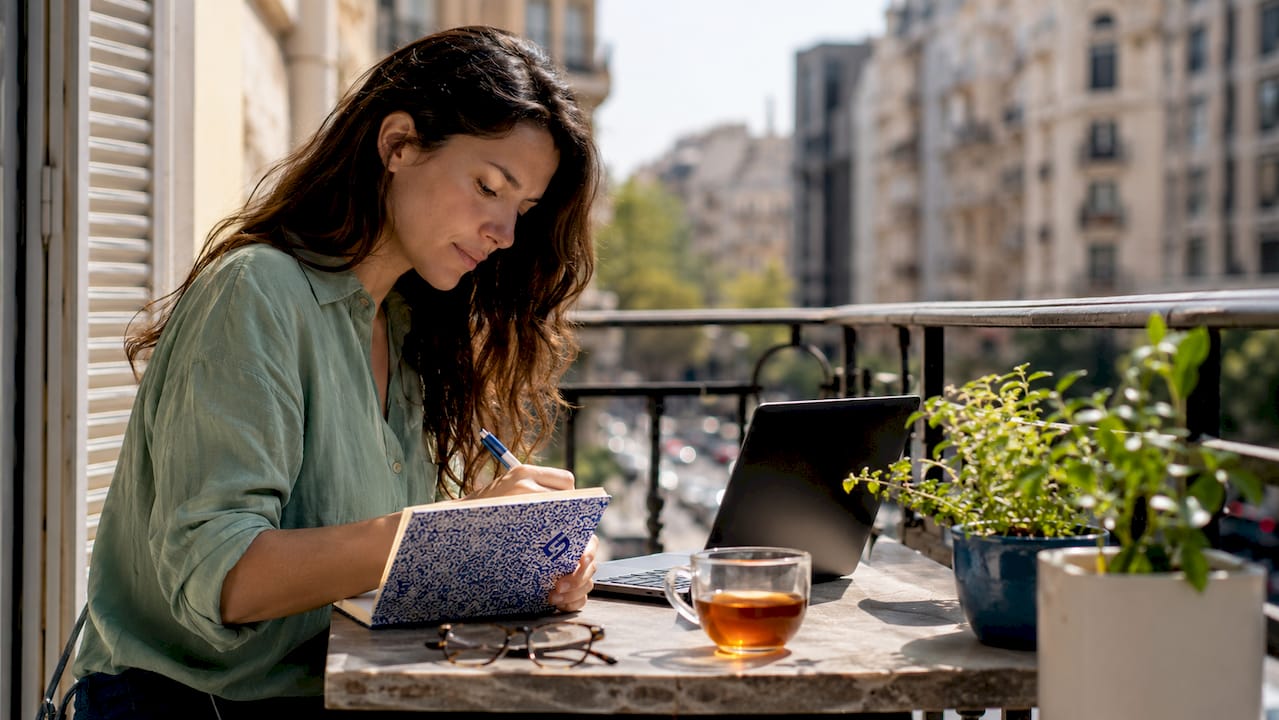 Woman writing value proposition notes at home desk