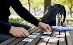 Hands arranging workflow cards on desk