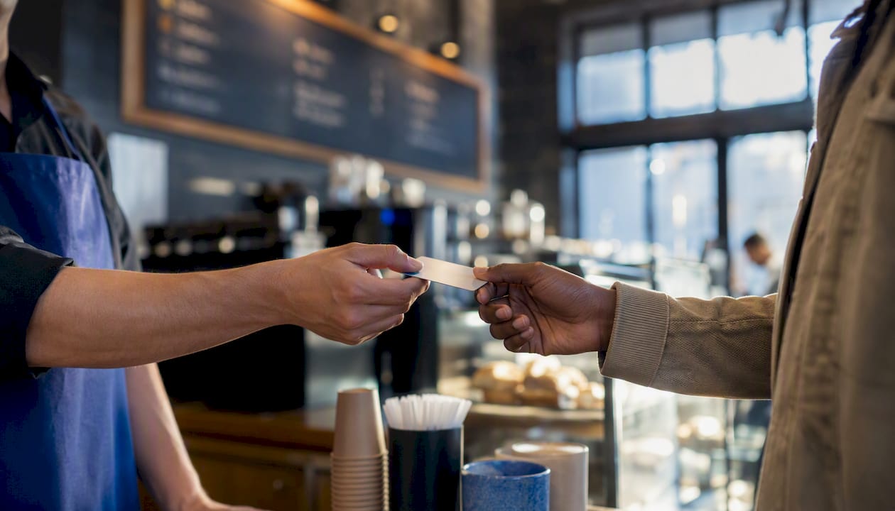 Hands passing loyalty card to customer
