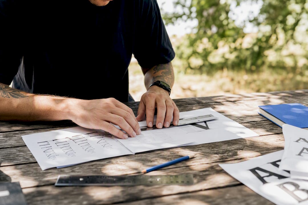 Hands adjusting font size and spacing on printed samples